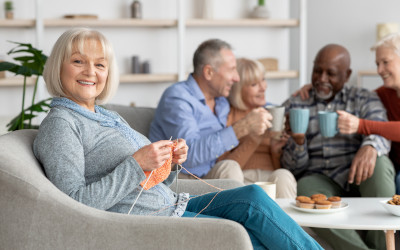 smiling grandmother in nursing home knitting